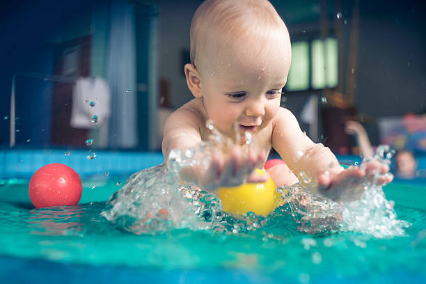 счастливый детские мальчик плещущиеся - floating on water water women wet стоковые фото и изображения