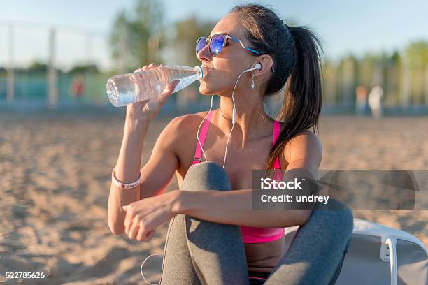 Beautiful Fitness Athlete Woman Drinking Water After Work Out Exercising Stock Photo - Download Image Now