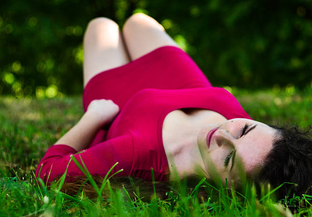 istock young woman lying on grass in summer forest 522786030