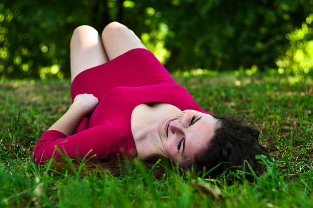 istock young woman lying on grass in summer forest smiling 522786858