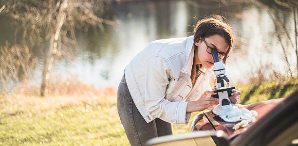 istock Teenage girl make outdoors scientific project with microscope 522789402
