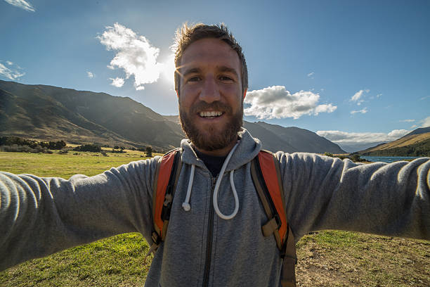 istock Cheerful young man on day hike takes self portrait 522790264