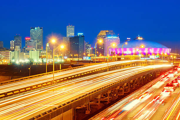 Skyline of New Orleans Louisiana USA City skyline photo of New Orleans Louisiana USA with traffic on highways, downtown skyscrapers and the Superdome, shot at twilight blue hour. blue hour twilight stock pictures, royalty-free photos & images