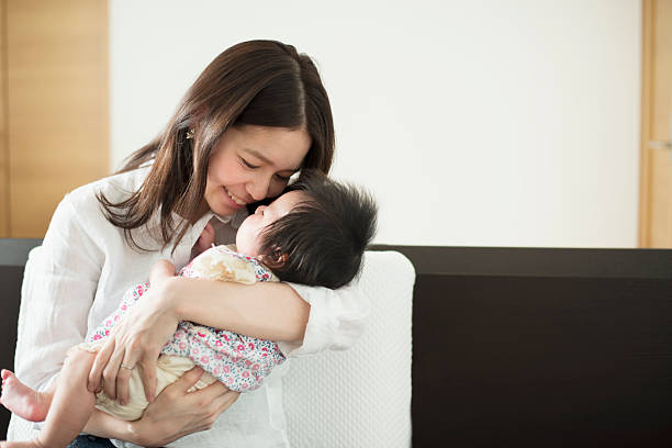 Young mother loving her baby girl at home Young asian mather having a good time with her cute baby girl on holiday at home 2 5 months stock pictures, royalty-free photos & images