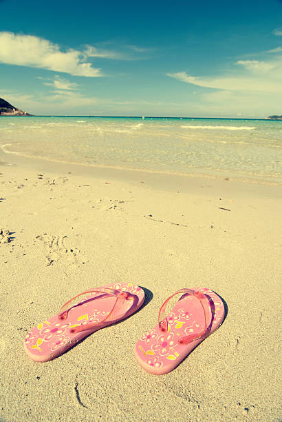 istock slippers on sand and beach with a retro effect 522793360
