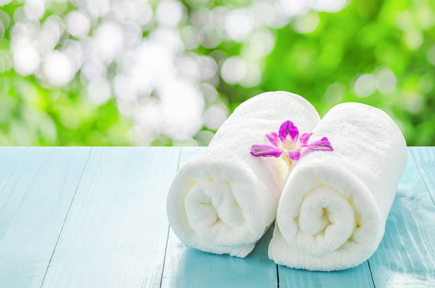 istock White towels roll with purple orchid flower 522793546
