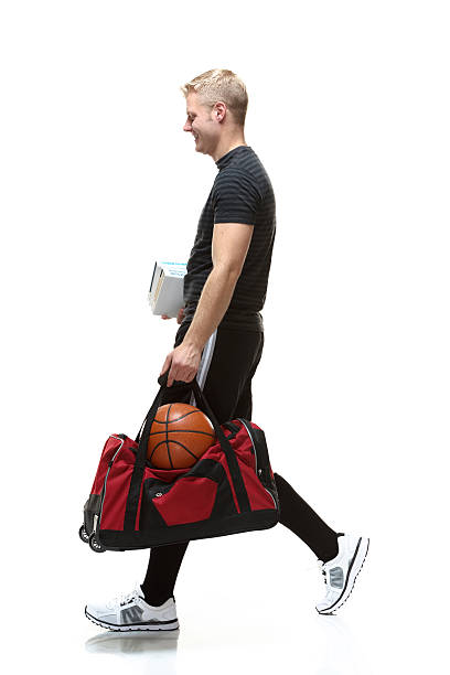 istock Smiling student walking with books and duffel bag 522793986