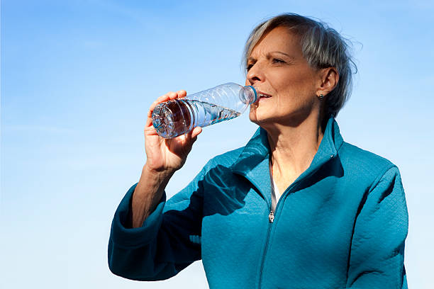 istock Mature Woman Drinking Water Under a Blue Sky 522795076