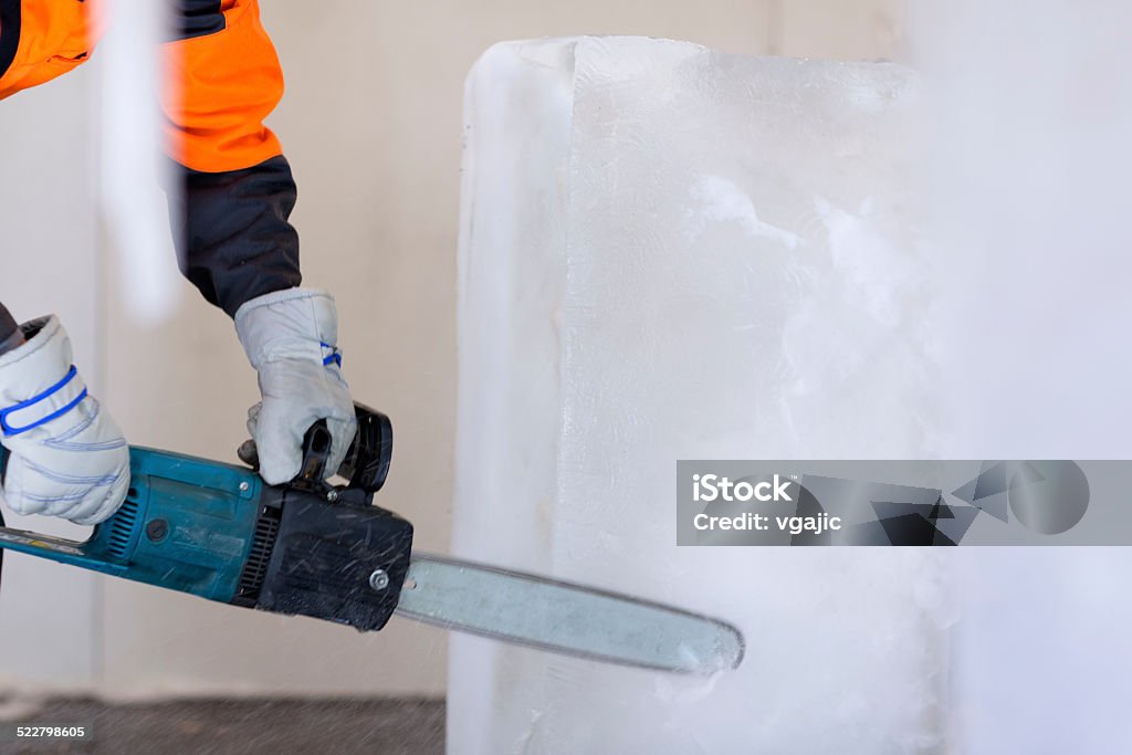 Ice carving. Women working with work tool, cutting ice block, making ice sculpture. Ice Sculpture Stock Photo