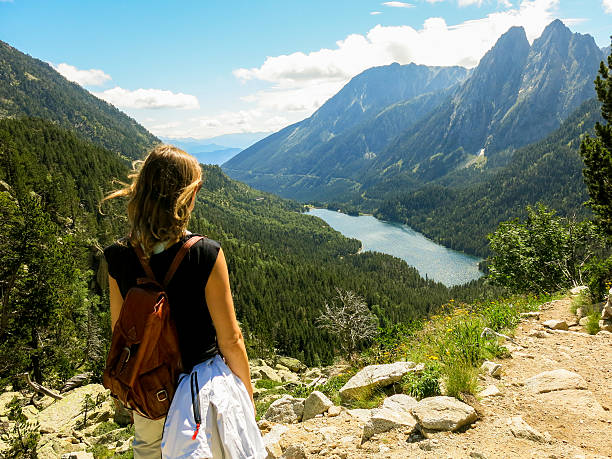 Girl looks at beautiful mountain view on a hike stock photo