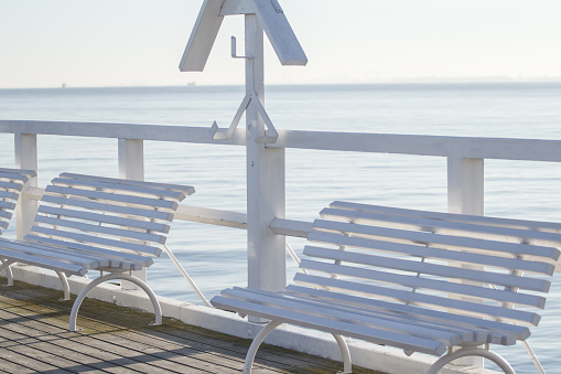 White wooden benches on sea pleasure pedestrian pier