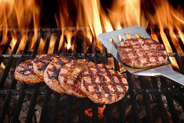 Beef Burgers On The Hot Flaming BBQ Charcoal Grill stock photo
