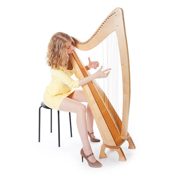 istock jonge vrouw in gele jurk speelt harp 522802735