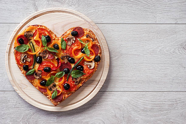 Baked heart-shaped homemade pizza stock photo