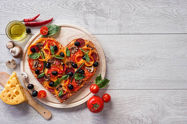 istock Tasty heart shaped pizza decorated with vegetables and herbs 522803138