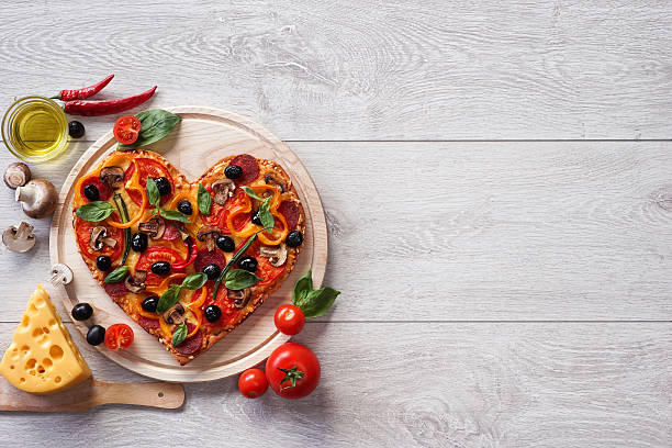 istock Pizza heart shape with ingredients and copy space 522803332