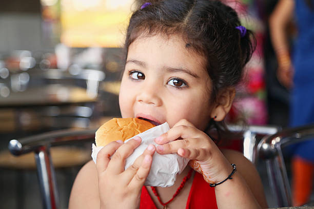 little girl eating burger - cafe buns eating bildbanksfoton och bilder