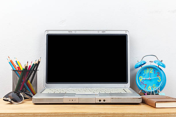 istock Laptop on workspace with leather notebook, alarm clock, glasses 522804900