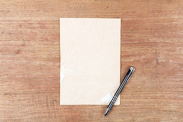 istock Old paper with black pencil on wooden table 522805624