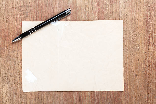istock Old paper with black pencil on wooden table 522805682