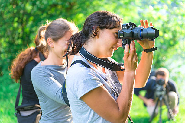 Participants in Photography Course Participants in a course in nature photography outdoors studying photos stock pictures, royalty-free photos & images