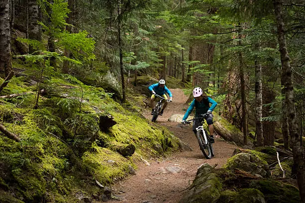 Photo of Couple mountain biking through a forest