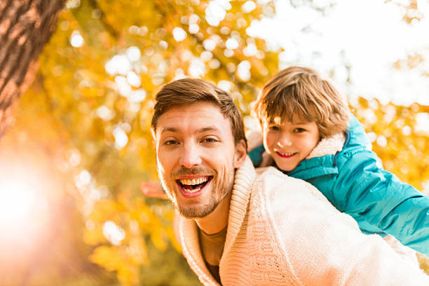 istock Father piggybacking son during autumn day. 522815773