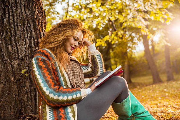 istock Woman reading a book in the park. 522815857