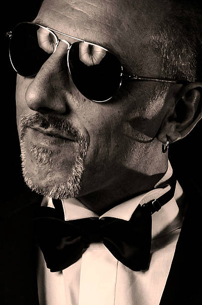 istock Stylish man in suit and bow tie wearing sun glasses 522817075