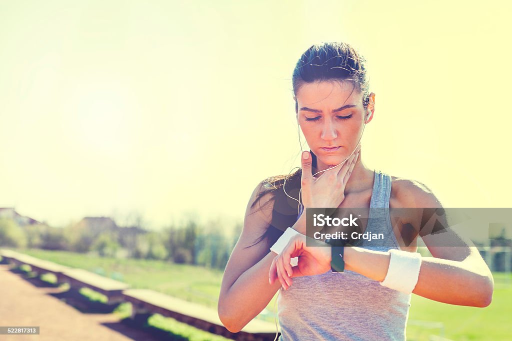 Young woman measuring heart rate after running Activity Stock Photo