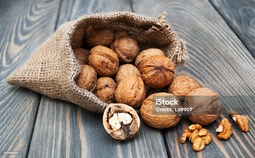Walnuts walnuts in burlap bag on old wood table Bag Stock Photo
