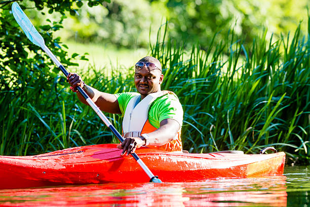 istock African Man paddling with canoe on forest river 522818567