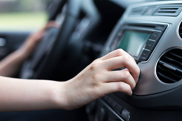 woman turning button of radio in car woman turning button of radio in car vehicle interior audio stock pictures, royalty-free photos & images