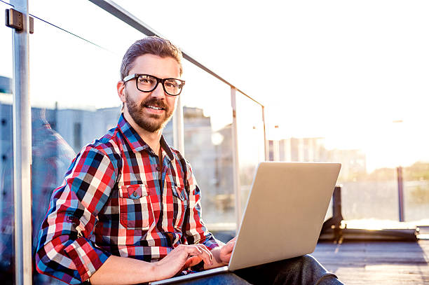 istock Businessman working from home on laptop, sitting on balcony 522849456