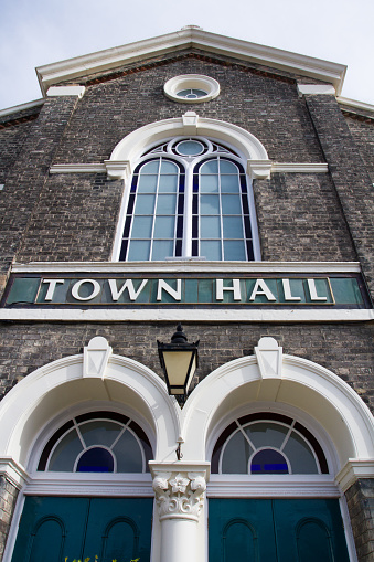 The facade of a traditionalTown Hall building with a large 'TOWN HALL' sign across the front.