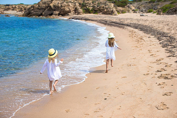 istock Adorable cute girls have fun on white beach during vacation 522851325