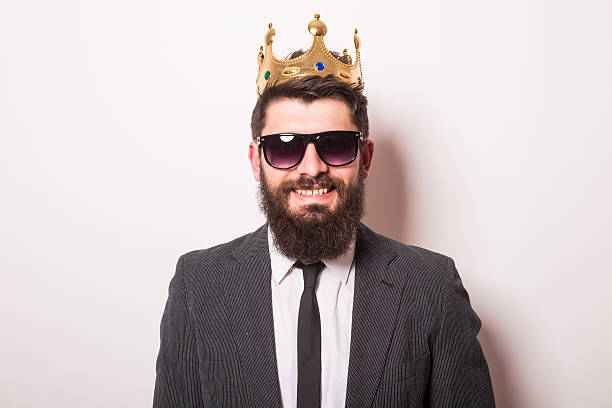 istock Portrait  young  man in suit with crown looking at camera 522851378