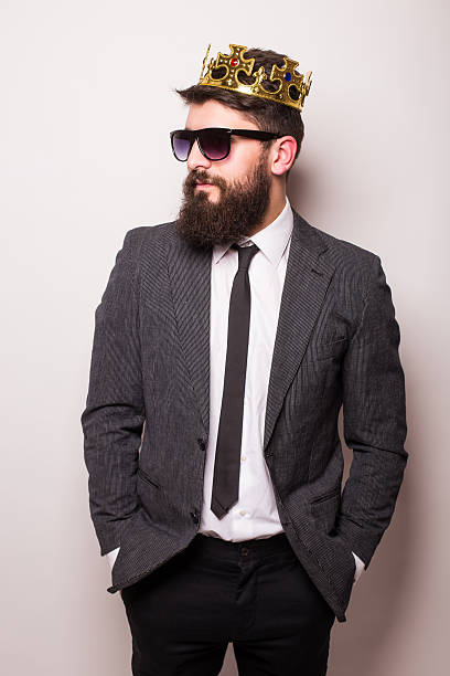 istock man  sunglasses wearing suit and crown keeping hand on jacket 522851586