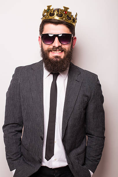 istock Young handsome man in sunglasses wearing suit and crown 522851728