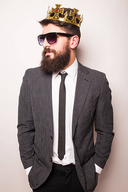 istock Young  man in sunglasses wearing suit, crown keeping hand  jacket 522851836