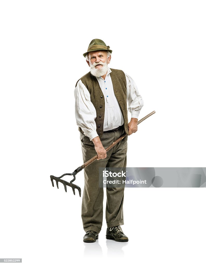 Old man with rake isolated Old bearded bavarian man in hat holding rake in his hand, isolated on white background 70-79 Years Stock Photo