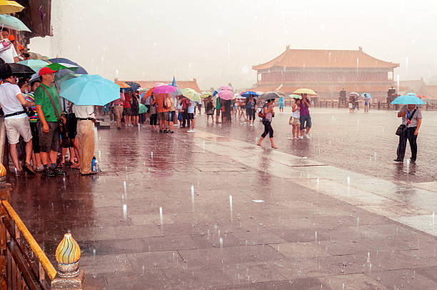 Tourists in Forbidden City, storm, Beijing, China Beijing, China - August 7, 2009: Lots of Chinese and foreign tourists in Forbidden. The stone floor in front is wet and reflects people and buildings, storm. The Forbidden City was the Chinese imperial palace from the Ming Dynasty to the end of the Qing Dynasty. It is located in the middle of Beijing, China, and now houses the Palace Museum. For almost five hundred years, it served as the home of emperors and their households, as well as the ceremonial and political centre of Chinese government. Built in 1406 to 1420, the complex consists of 980 buildings with 8,707 bays of rooms. Nikon D300. Copy space. forbidden city beijing architecture chinese ethnicity stock pictures, royalty-free photos & images
