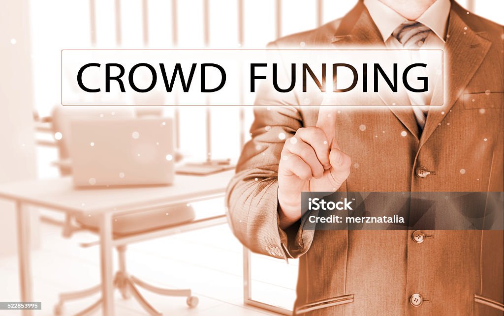 Businessman pushes virtual crowd funding button Adult Stock Photo