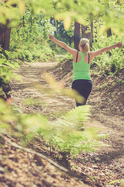 istock Young blonde woman running in the forest, stretching 522855622