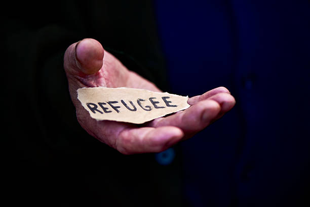 istock old man with a paper with the word refugee 522856070