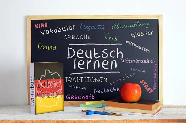 Blackboard in a German language classroom with the message LEARN GERMAN and some text