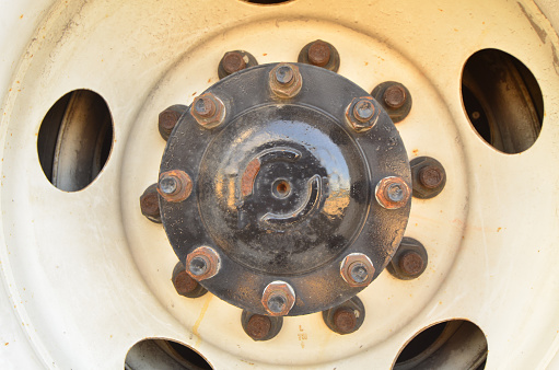 Truck axle hub with eight bolts, through a white rim with oval cutouts