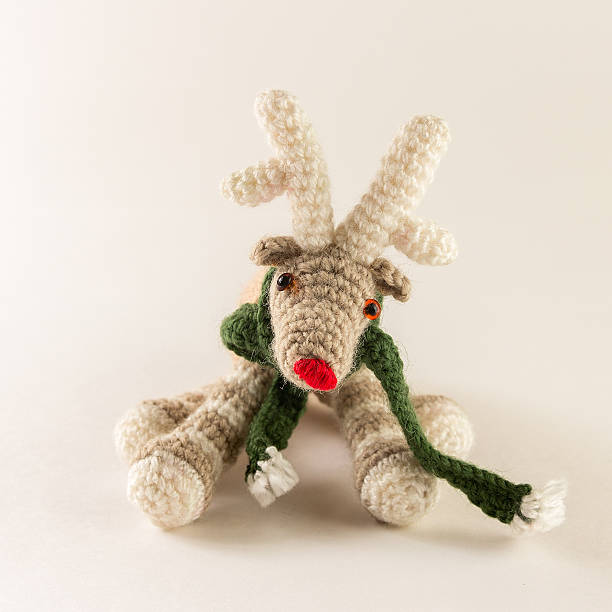 istock Cute knitted deer toy with green scarf 522865430