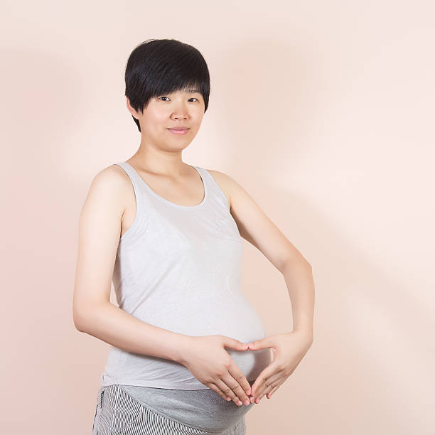 istock Pregnant women heart-shaped gesture 522866056