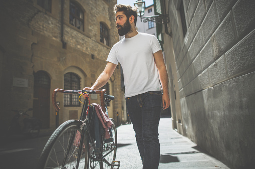 Hipster  guy walking with bicycle